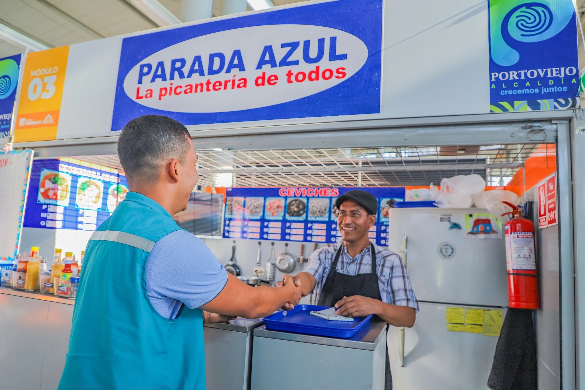 Funcionario de PortoComercio dandole la mano a un Comerciante